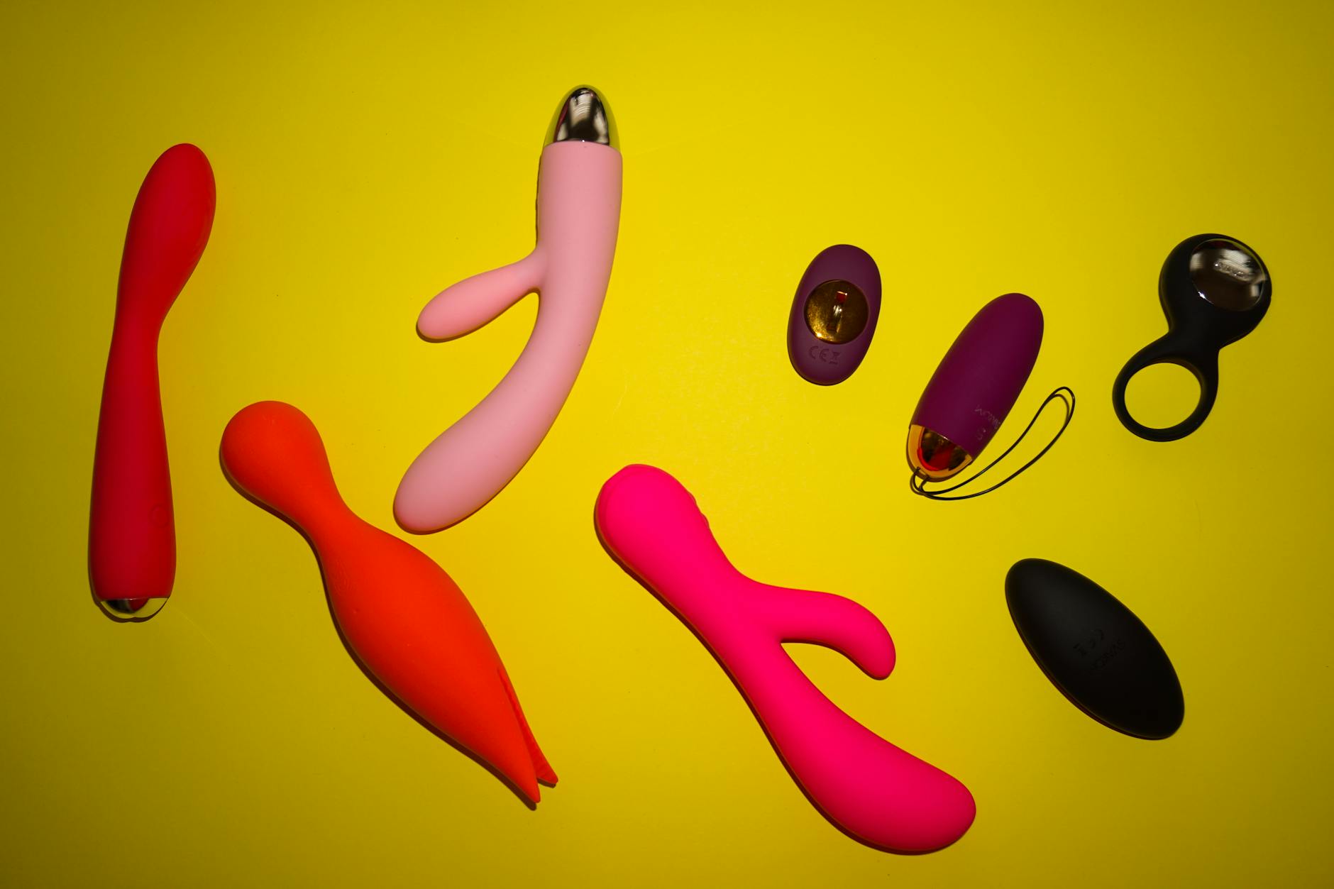 Hands holding pastel-colored silicone toys on a soft neutral background
