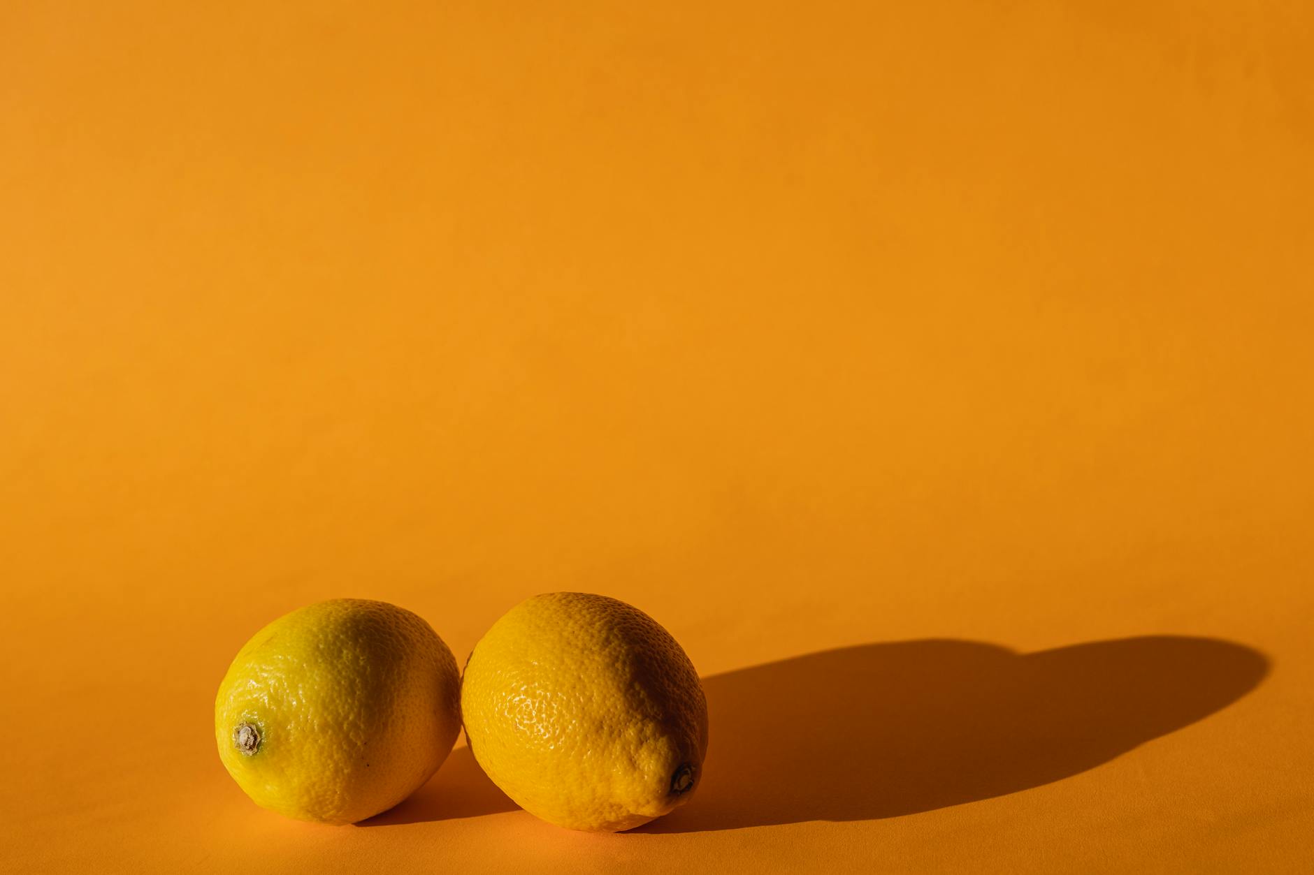 Bright yellow lemons arranged on a sunny background, symbolizing the lemon vibrator brand.
